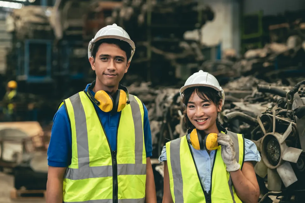 Dos trabajadores sonrientes de trabajar seguros y con prevención laboral. 