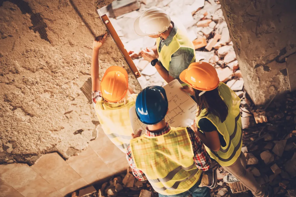 4 técnicos inspeccionando una construcción dañada